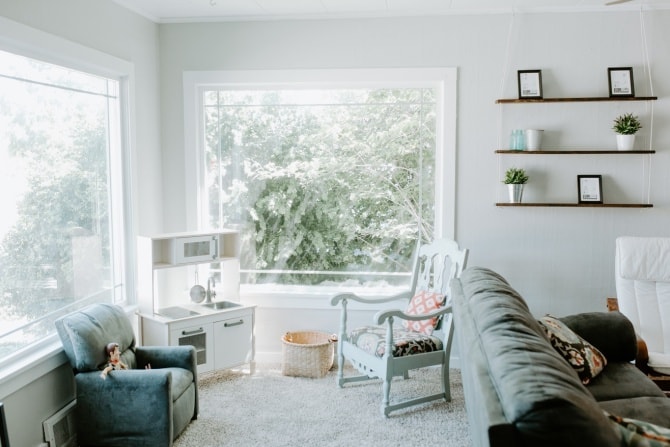 living room corner with rustic chair and hanging rope shelf