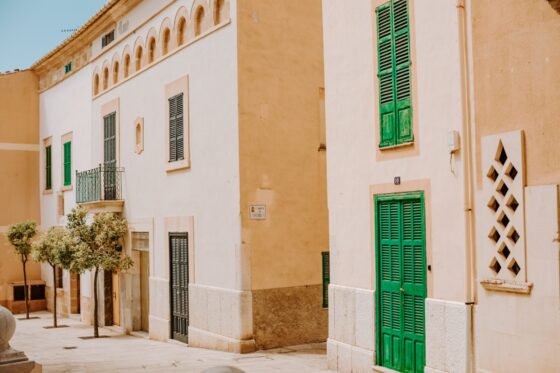 Alcudia architecture with green shutters and pink sandstone buildings