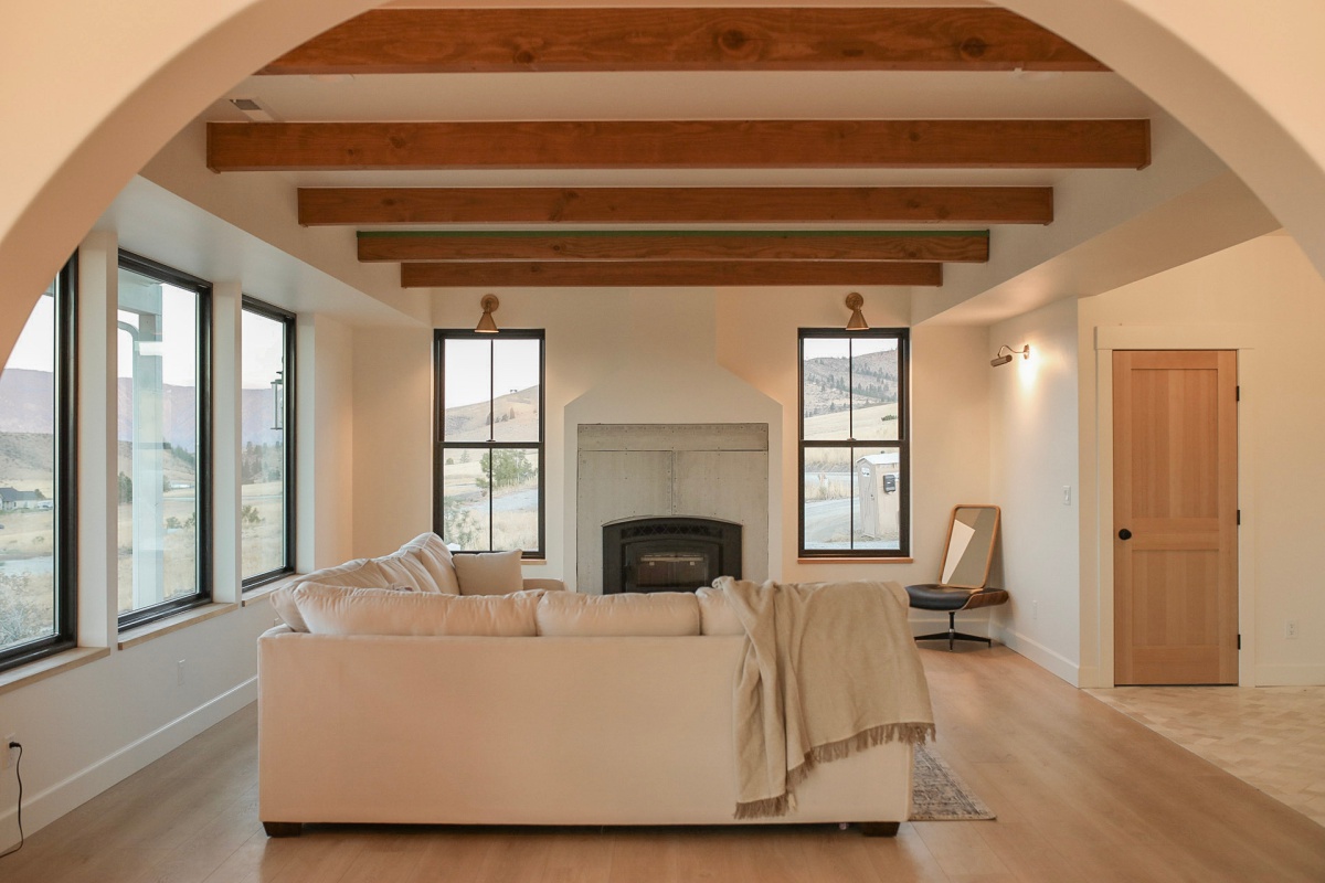 Farmhouse open concept living room with wood beams and windows