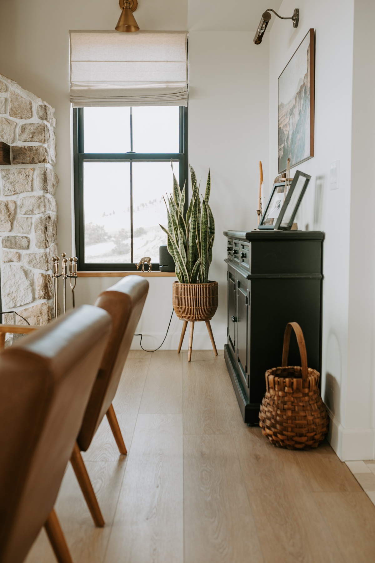 Stone fireplace with window sconce and basket planted snake plant